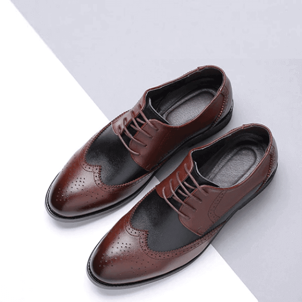 Pair of two-tone brown and black men's leather dress shoes with brogue detailing